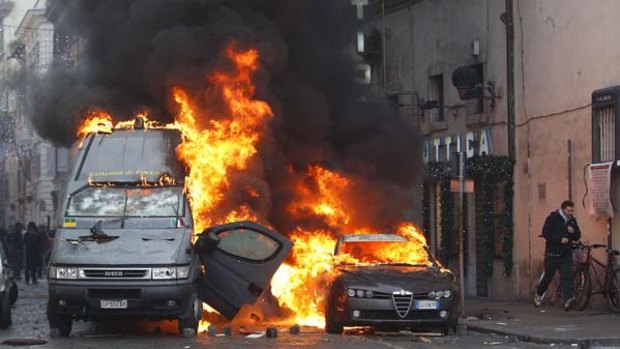 Protests ... A Guardia di Finanza vehicle burns near the parliament during anti-government clashes in Rome.