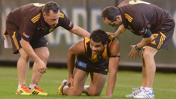 Hawthorn's Cyril Rioli winces after injuring his hamstring.