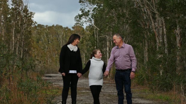 Ian and Carolyn Thomson, the parents of the late Canberra track worker Riharna Thomson, with their younger daughter Bessie, seven, at their home in Salamander Bay on Friday. They say confronting the issue of Riharna's organ donation was difficult but ultimately the best thing for their recovery.