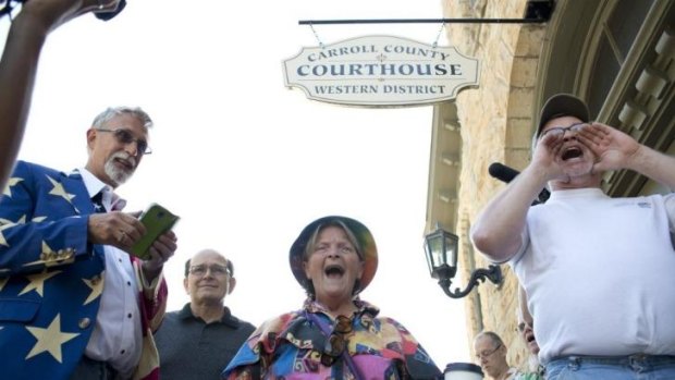 Sheila McFadden, centre, and Ken Riley, right, yell words of encouragement at a crowd gathered in front of the Carroll County Courthouse on Saturday, where gay couples were applying for marriage    licenses.
