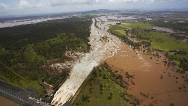 Overwhelmed ... water that has to be released from the Wivenhoe dam spills from the gates and spreads far across the plain, heading for Brisbane about 80kms away.