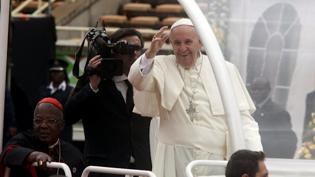 Pope Francis waves as he arrives for a meeting with youths at Kasarani Stadium, in Nairobi.