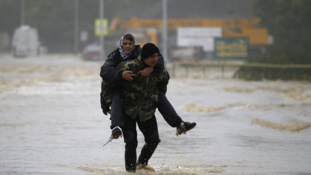 A man carries a woman through a flooded street in the town of Obrenovac, east from Belgrade.