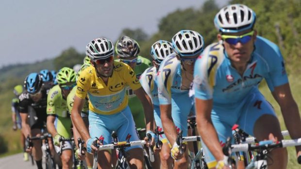 Italy's Vincenzo Nibali, wearing the overall leader's yellow jersey, rides with his teammates in the pack during the eleventh stage of the Tour de France.