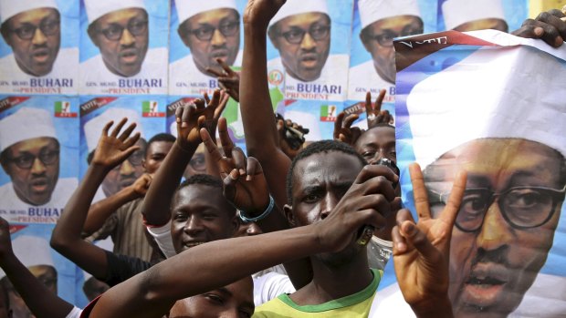 Supporters of presidential candidate Muhammadu Buhari gesture in front of his election posters in Kano on Saturday. 