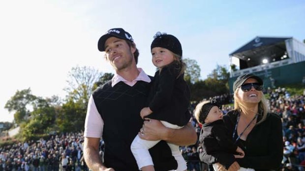 Dad's army . . . Aaron Baddeley after his Los Angeles Open triumph on Sunday. He's holding two-year-old daughter Jewell, accompanied by his wife Richelle and baby Jolee.