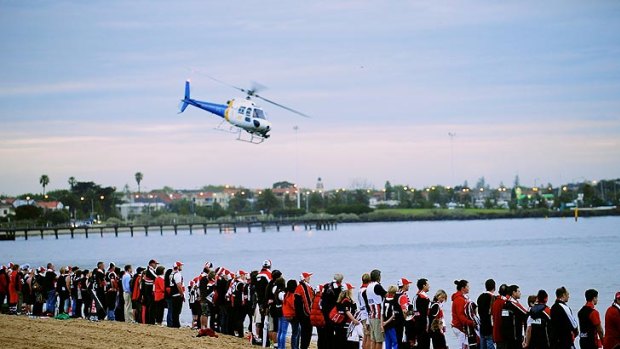 About 1000 people gathered at St Kilda beach for St Kilda Football Club's membership drive before the heavens opened this morning.