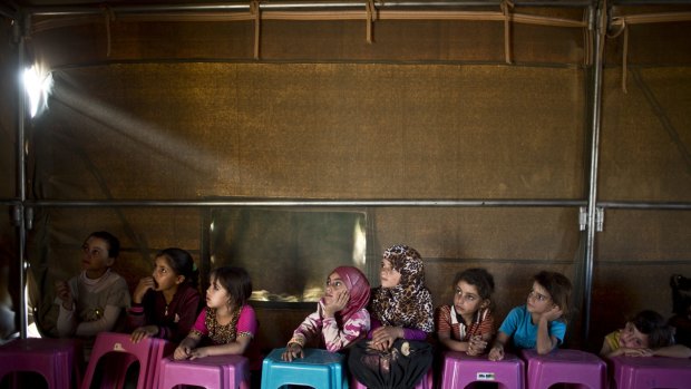 Syrian refugee children attend a class at a makeshift school in a tent at an informal settlement on the outskirts of Mafraq, Jordan, near the Syrian border.