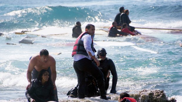 A man rescues a migrant from the Aegean sea, in the eastern island of Rhodes.