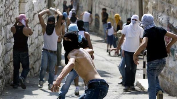 Clashes ... Palestinian youths throw stones in east Jerusalem.