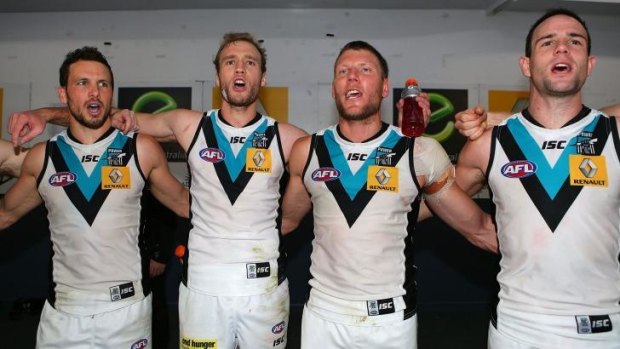 Port Adelaide players sing the club song in the rooms after defeating Fremantle on Saturday.