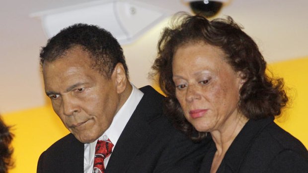 Boxing great Muhammad Ali, with his wife, Lonnie, right, looks down from a balcony at friends attending a celebration for his 70th birthday at the Muhammad Ali Center on Saturday, Jan. 14, 2012, in Louisville, Ky. Ali turns 70 Tuesday.
