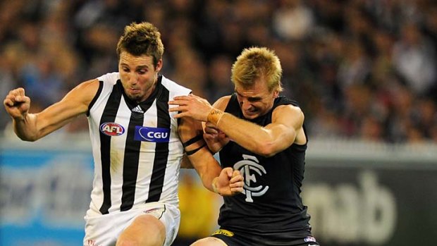 Carlton's Dennis Armfield battles with Magpie Dale Thomas at the MCG last Friday night.