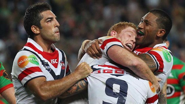 Get a grip . . . Rooster Tom Symonds is swamped by teammates Braith Anasta, left, Mose Masoe, right, and Jake Friend, No.9, after scoring against the Rabbitohs.