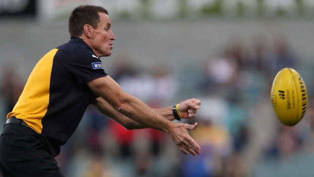 Eagles coach John Worsfold handballs as his team warms up during the round four AFL match between the West Coast Eagles and the Carlton Blues.
