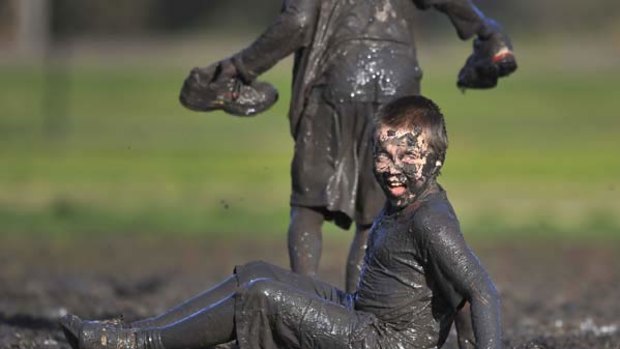 My name is mud: Finn Hanrahan enjoys the wet conditions at yesterday's Community Cup at Elsternwick Park.