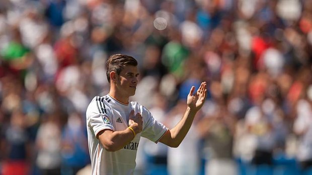 Gareth Bale waves to fans in his new Real Madrid shirt during his official unveiling at the Santiago Bernabeu on Monday.