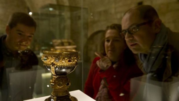 Two employees of of the museum and a guest watch what was known until now as the goblet of the Infanta Dona Urraca - daughter of Fernando I, King of Leon from 1037 to 1065 - in the museum of the Basilica of San Isidoro in Leon, northern Spain.