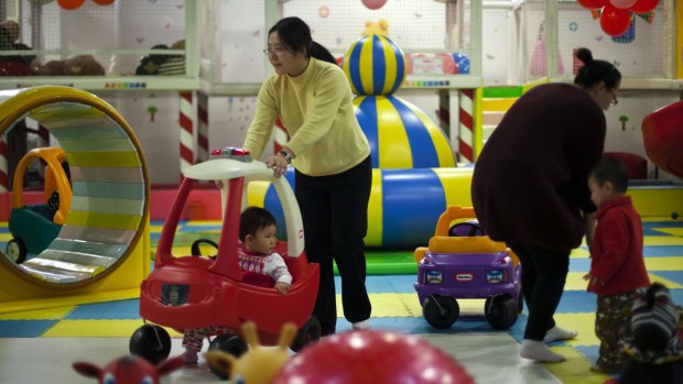 Gender imbalance: Parents and their children at a play area in a shopping mall in Beijing.