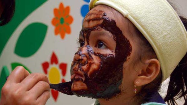 Nadra Rani, 5, patiently sits through a chocolate facial courtesy of her mother, a Jakarta salon manager. <i>Picture: Mosista Pambudi</i>