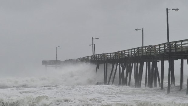 Waves pound a fishing pier in Nags Head, North Carolina.