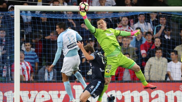 Sydney goalkeeper Danny Vukovic makes a save as Tim Cahill jumps for the ball.