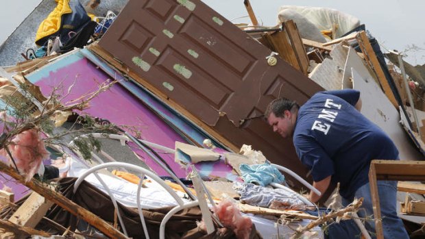 A resident who did not want to give his name, searches through the rubble of his mobile home in the Steelman Estates Mobile Home Park, destroyed by a tornado on Sunday, near Shawnee, Oklahoma on Monday, May 20, 2013.