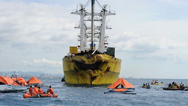 Hundreds missing: Life rafts from the sunken ferry St. Thomas Aquinas float in front of a cargo ship on whose bow was destroyed after a colliding with the ferry.