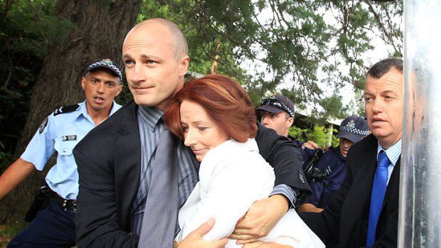 Prime Minister Julia Gillard is dragged to safety amid the protests on Australia Day.