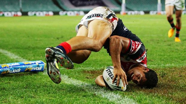 Roger Tuivasa-Sheck of the Roosters dives over to score a try in the corner.