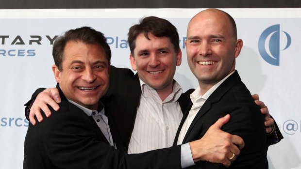 Planetary Resources co-founders and co-chairmen Peter H. Diamandis, left, and Eric Anderson, right, embrace president and chief engineer Chris Lewicki following their news conference.