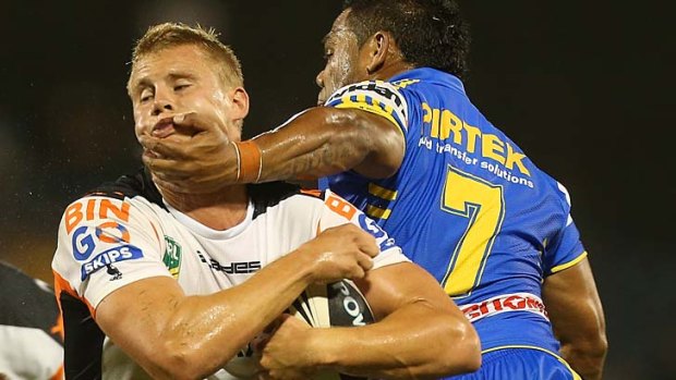 Chin music &#8230; Tigers No.7 Jacob Miller is collared by Chris Sandow on Saturday night.