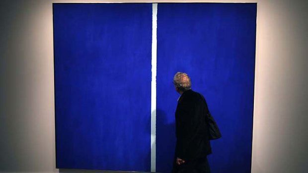 A visitor walks past Barnett Newman's <i>Onement VI </i>during a Sotheby's preview in New York.