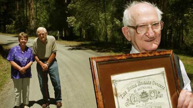 Norm Golding (right), holding his bravery award, with Noreen Warren and Ted Chisholm.