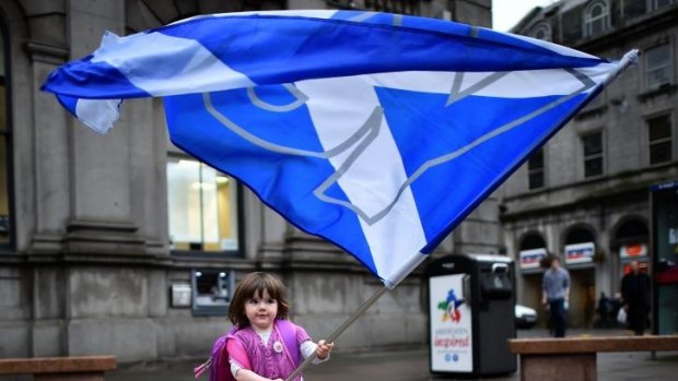 A child plays with a pro-independence "yes" flag on the streets of Aberdeen in Scotland, ahead of the referendum on Scotland's independence.