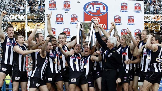 Coach Mick Malthouse and the Collingwood team celebrate in 2010 after winning the club's first premiership in 20 years.