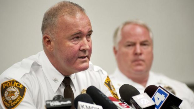St Louis County Police Chief Jon Belmar, left, delivers remarks as Ferguson Police Chief Thomas Jackson listens during a news conference on Sunday.