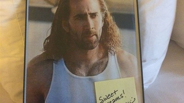 Nicholas Cage in a scene from Con Air with a note from the concierge.