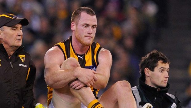 A grim-faced Jarryd Roughead is ferried off the ground.