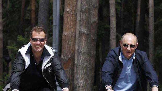 Along for the ride ... Russian president Dimitri Medvedev, left, and prime minister Vladimir Putin, ride bikes through a Moscow park.