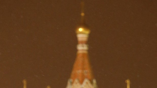 A worker clears snow in Red Square, in Moscow with St Basil's Cathedral  in the background.  
