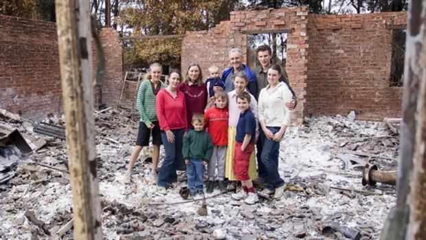 Still smiling, the Lisle family take time out from sifting through the ashes of their home to pose and grin for the cameras. 