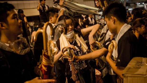 Protesters hand out piles of umbrellas in the early hours of the morning outside the Hong Kong Government Complex in Hong Kong.