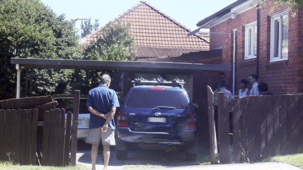 Family friends and detectives at the driveway of a Wahroonga house where the toddler was run over.