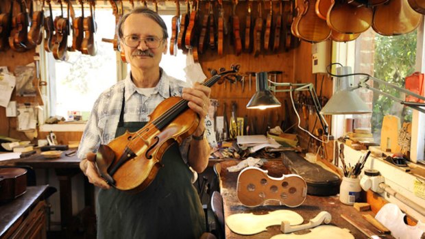 John Ferwerda holds a violin once owned by the late concert master Leonard Dommett. The  instrument, made in 1727, is valued at more than $100,000.