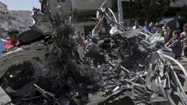 The wreckage of a vehicle following an Israeli air strike on the main street in Gaza City.