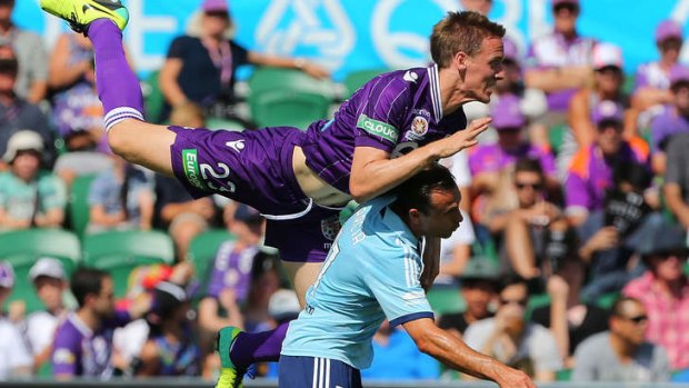 Michael Thwaite of the Glory lands on Richard Garcia of Sydney FC in round four.
