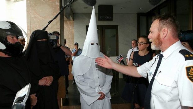 Security turn away protesters with facial coverings from Parliament House.