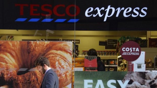 A customer passes a branch of the Tesco Express convenience store in central London. 
