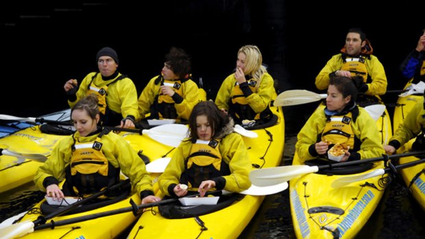 Over-water dining ... City Kayak Tour paddlers tuck into a fish and chip dinner.